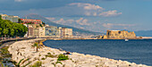 Blick auf pastellfarbene Architektur, Restaurants und das Schloss Ovo an der Uferpromenade der Via Partenope und den Vesuv, Neapel, Kampanien, Italien, Europa