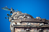 Low angle view of the Giraldillo statue atop La Giralda in Seville, Andalusia, Spain, against a clear blue sky.