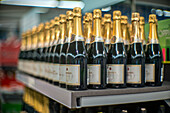 A shelf filled with French champagne bottles is displayed in a shop in Seville, Spain. The image is taken with a wide aperture, creating a shallow depth of field.