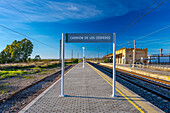 A picturesque railway station in Carrion de los Cespedes, Sevilla, Andalusia, Spain, bathed in sunlight with an open sky.