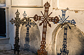 Eisenkreuze werfen Schatten im Cementerio Catolico de Aznalcazar in der Provinz Sevilla, Andalusien, Spanien, und vermitteln eine düstere und historische Atmosphäre.