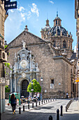 Stunning view of the historic Church of Santos Justo y Pastor in Granada, Spain. Captures the intricate architecture and vibrant street life around this landmark.