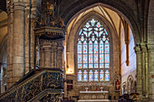 Beautiful interior view of the Notre Dame du Roncier Basilica in Josselin, Brittany, France, showcasing stunning stained glass windows and ornate architectural details.