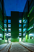 Night view of the Facultad de Biología at the Campus de Reina Mercedes, Universidad de Sevilla, showcasing modern architecture.