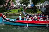 Bootsfahrt durch Kanäle in einem farbenfrohen und traditionellen Moliceiro-Boot, Aveiro, Portugal