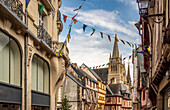 Eine lebendige Ansicht des Stadtzentrums von Vannes, Bretagne, Frankreich, mit der Kathedrale Saint-Pierre, festlichem Straßenschmuck und schöner Architektur.