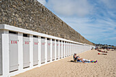 Beachgoers enjoy a sunny day by the sea at the historic Port Louis Citadelle, Lorient, Brittany, France.