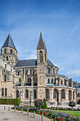 Historische Männerabtei in Caen, Normandie, Frankreich mit beeindruckender Architektur und einem gepflegten Garten an einem sonnigen Tag.