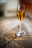 A glass of Palo Cortado sherry sits on a wooden table in Seville, Spain.