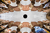 Fisheye view from below capturing intricate arches and ceiling inside the historic Cordoba Mosque located in Andalusia, Spain.