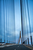 Blurred view of the Guadiana International Bridge connecting Spain and Portugal, captured from a moving car.