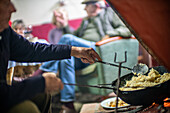 Cooking traditional Migas Serranas in a cozy setting in Villaviciosa de Córdoba, Andalusia, Spain. A warm and inviting atmosphere with friends and family.