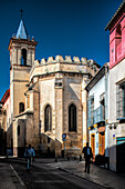 Straßenansicht der historischen Kirche San Esteban in Sevilla, Spanien, mit ihrer gotischen Mudéjar-Architektur an einem sonnigen Tag.