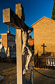 Detailed crucifix statue in the serene setting of Cementerio de San Fernando, Sevilla, Andalucia, capturing a peaceful and reflective atmosphere.