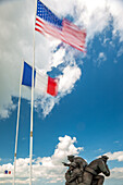 Foto eines Denkmals mit amerikanischer und französischer Flagge am Utah Beach, das an die historischen Ereignisse in der Normandie, Frankreich, erinnert.