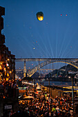 Start von Heißluftballons über der Brücke Luis I und dem Fluss Douro während des Johannisfestes (Festa de Sao Joao do Porto) in der Nacht zum 23. Juni (Johannisnacht) in Porto, Portugal