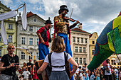 Künstlerin spielt Geige, während sie auf Stelzen bei der Puppenparade vom Marienplatz zum Altstädter Ring läuft, während des Prager Straßentheaterfestivals Behind the Door, Prag, Tschechische Republik