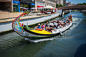 Boat ride through canals in a colorful and traditional Moliceiro boat, Aveiro, Portugal