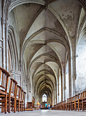 Majestic interior view of Eglise Saint Pierre in Caen, Normandy, France. People walking through the historic Gothic architecture.