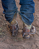 Stiefel und Sporen eines Rodeo-Cowboys vor seinem Bareback-Bucking-Wettbewerb bei einem Rodeo in Utah.