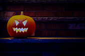 Illuminated Halloween jack-o-lantern on porch at night