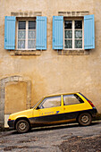 Yellow postal delivery vehicle parked outside a townhouse