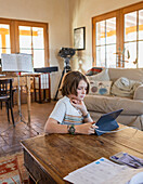 Boy looking at digital tablet at table in living room