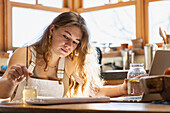 Teenage girl painting with watercolors at table