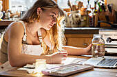 Teenage girl painting with watercolors at table