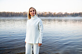 Portrait of woman in white sweater on lakeshore