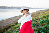 Portrait of woman in white hat on lakeshore