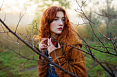 Portrait of redhead women in foggy field in autumn