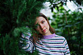 Portrait of woman standing in greenhouse