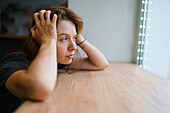 Woman leaning on window sill and looking through window