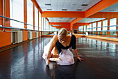 Ballerina sitting on floor in ballet studio