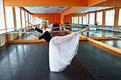 Porträt einer auf dem Boden sitzenden Ballerina im Ballettstudio