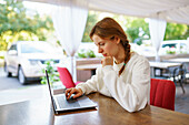 Woman using laptop at cafe table