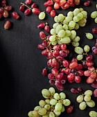 Red and green grapes on a black background