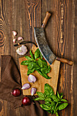 Basil, red onions and garlic on wooden board