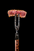 Medium rare steak on a fork