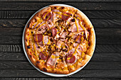 Pizza with ham, salami and onions