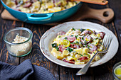 Potato casserole with sausage, leek and horseradish sauce