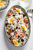 Reissalat mit gekochten Eiern, Oliven, Tomaten und Champignons