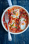 Shakshuka with eggs and vegetables in tomato sauce