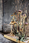 Golden flamingo sculptures with dried flowers in rustic room