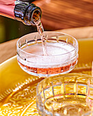 Rosé champagne is poured into the glass