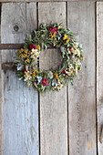 Trockenblumenkranz an einer Holzwand