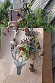 Gift bag with fir branch, cones and deer hanging on the door of a mountain hut