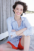 Young woman in light blue shirt dress and shorts