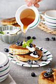 Blaubeer-Pancakes mit Ahornsirup und frischen Blaubeeren